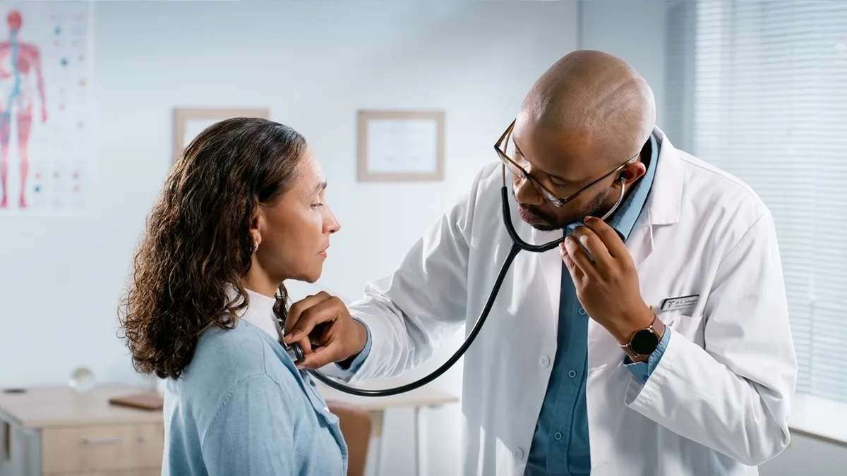 Un médecin ausculte une patiente dans un cabinet médical lumineux