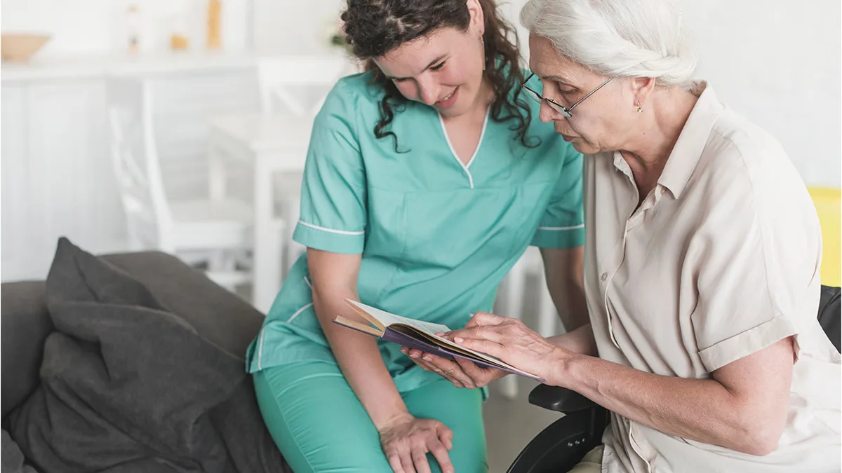 Une aide-soignante accompagne une personne âgée