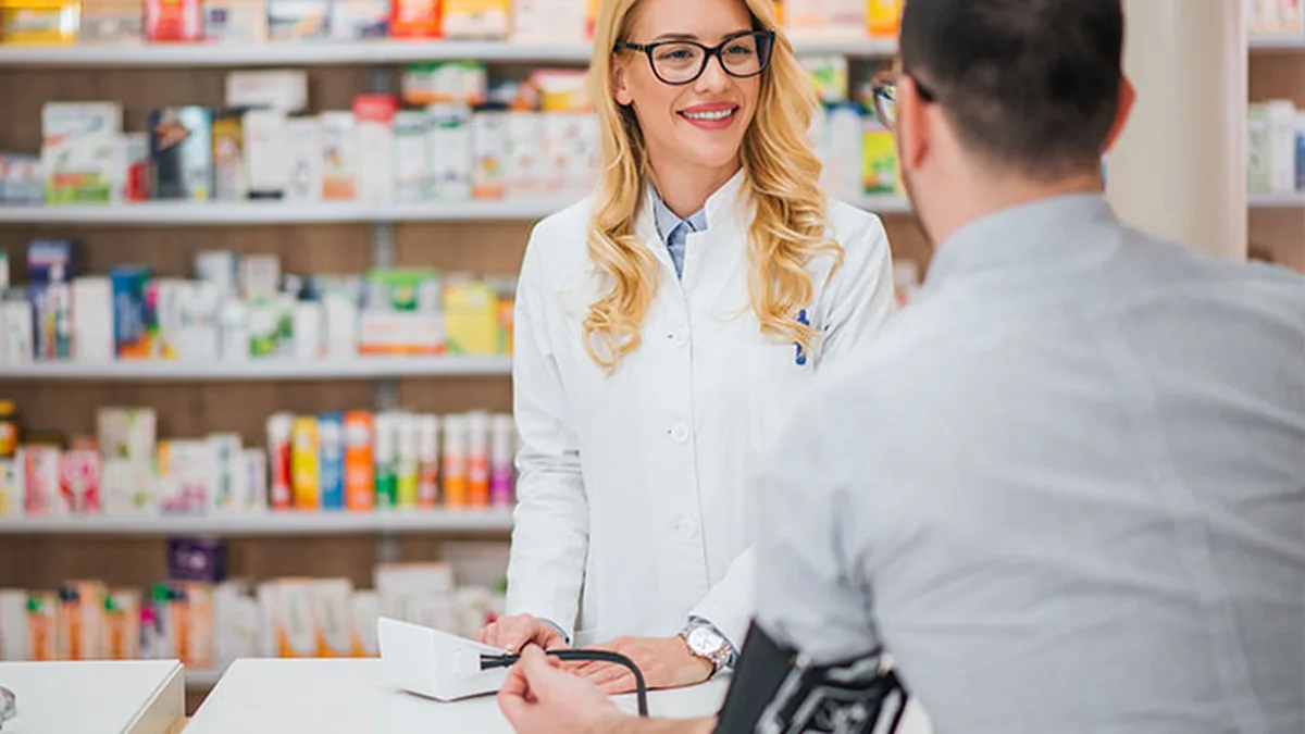 Une pharmacienne mesure la tension artérielle d&rsquo;un patient en pharmacie