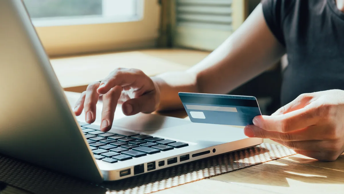 Achat en ligne avec une carte bancaire devant un ordinateur portable