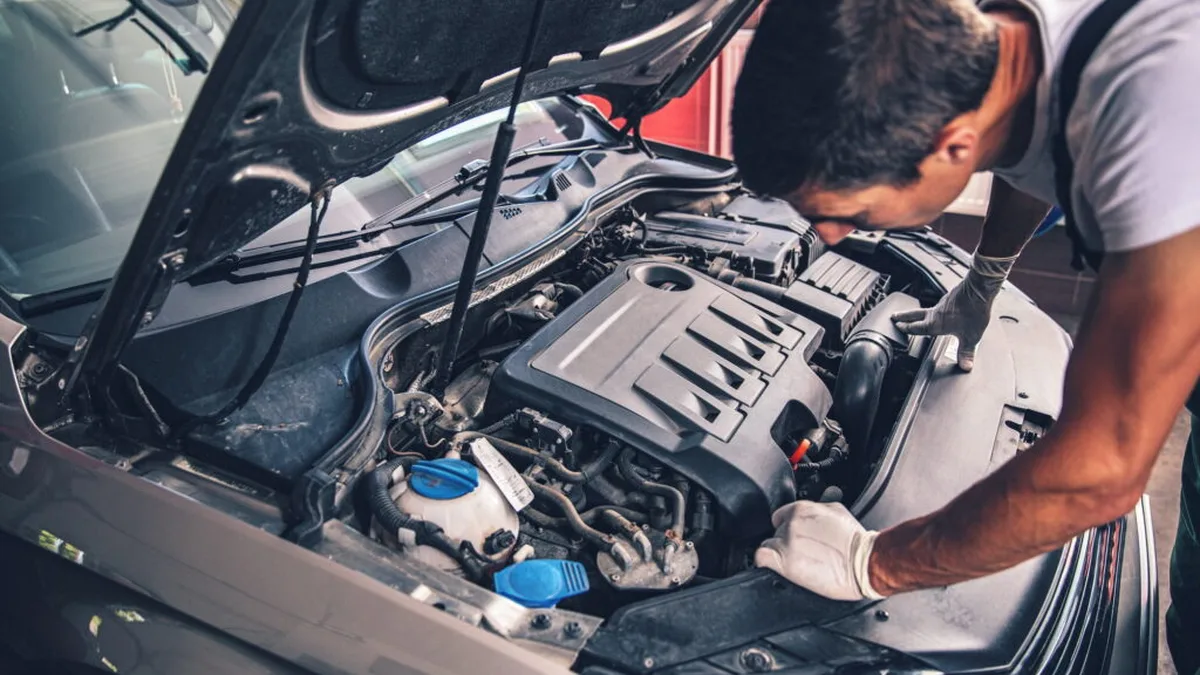 Un mécanicien travaille sur le moteur d&rsquo;une voiture essence lors de la pose d&rsquo;un boîtier E85