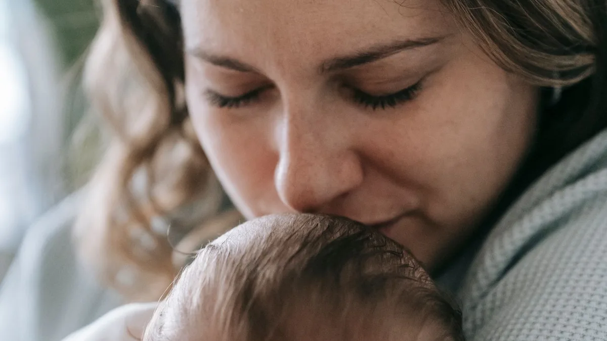 Une mère tient son nouveau-né contre elle, à la lumière du jour