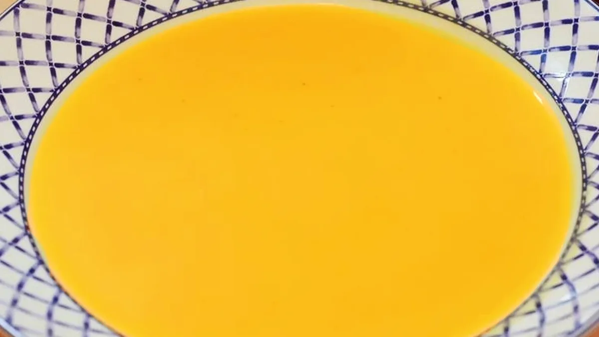 Velouté de citrouille servi dans un bol, parsemé de graines grillées