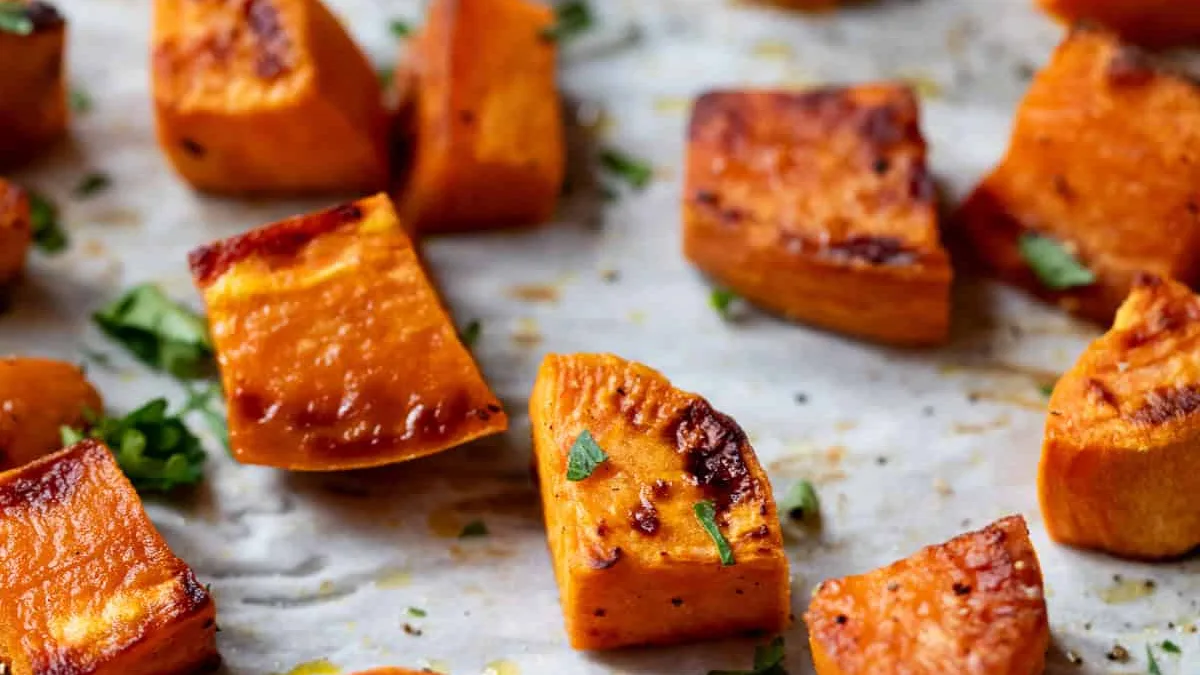 Cubes de patate douce rôtis au four, dorés et caramélisés, sur une plaque