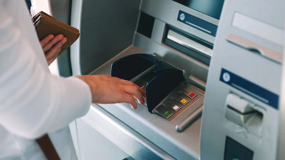 Un client utilise un distributeur automatique de billets
