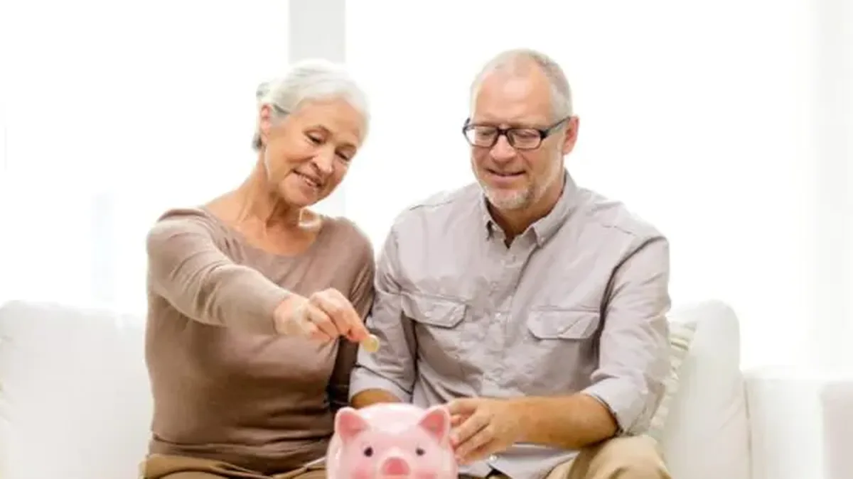 Un couple de seniors met de l&rsquo;argent de côté dans une tirelire