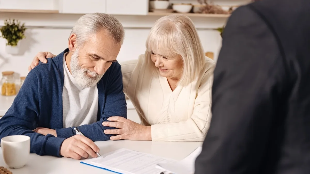 Un couple de seniors signant des documents