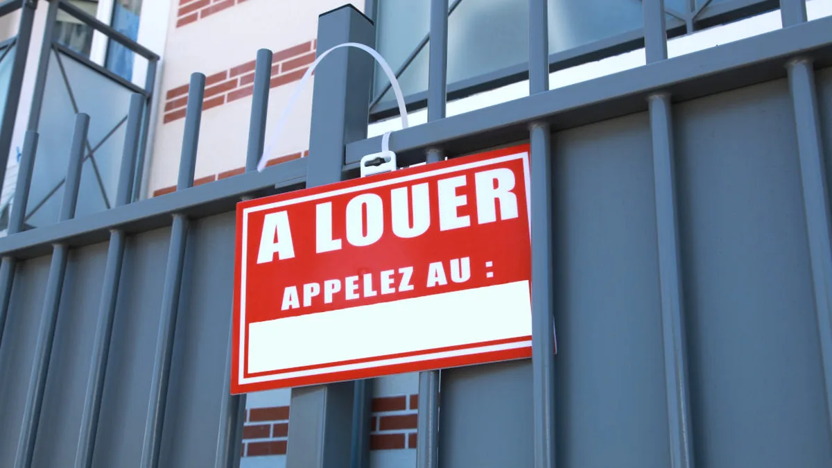 Un panneau « À louer » accroché à une grille d&rsquo;immeuble