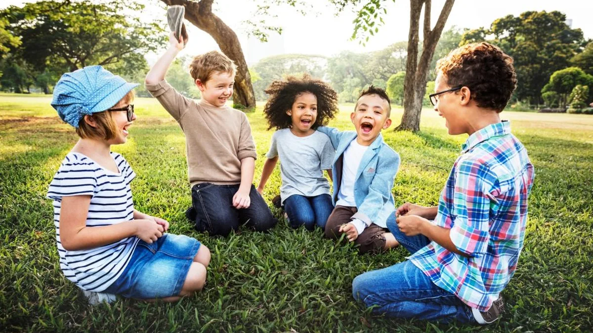 Des enfants rient et jouent ensemble dans un parc, loin des écrans