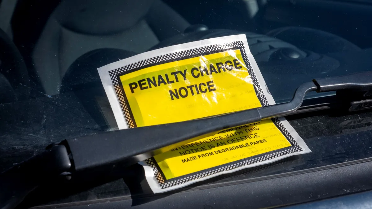 Une contravention de stationnement glissée sous un essuie-glace