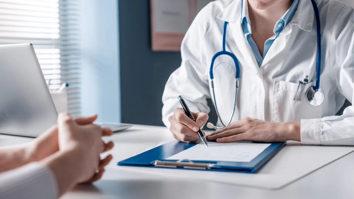 Une médecin rédigeant une ordonnance : les malades chroniques et les patients suivis régulièrement seront les plus exposés aux nouveaux plafonds