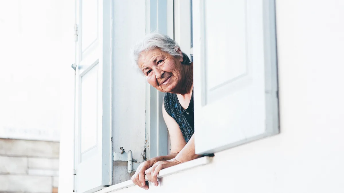 Une retraitée à sa fenêtre : le retour à 62 ans concernerait tout le monde, avec des départs différenciés selon la pénibilité