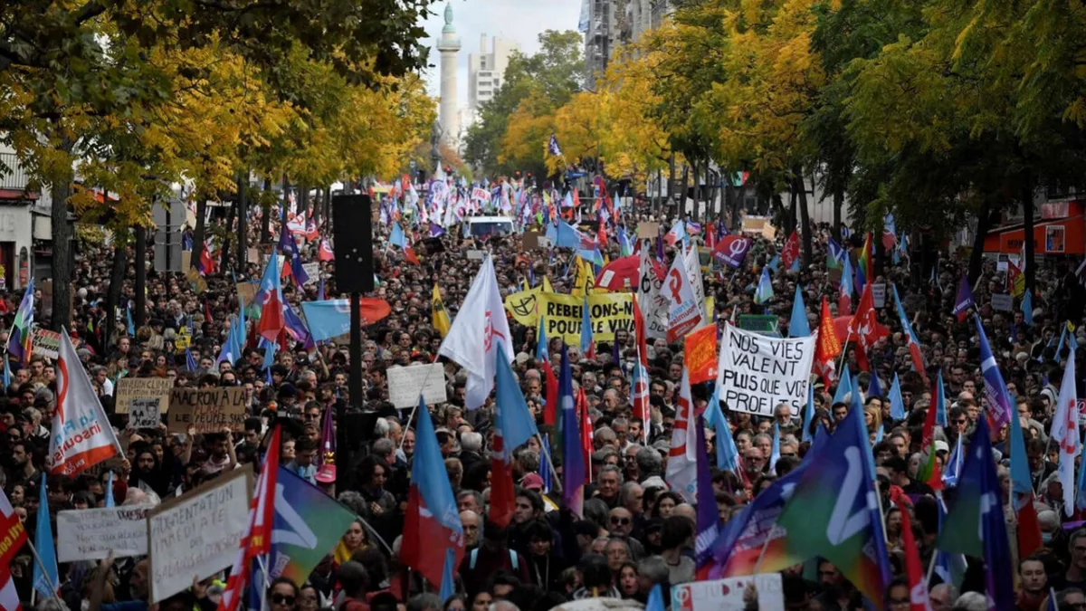 Une manifestation massive dans une grande avenue parisienne, drapeaux syndicaux levés