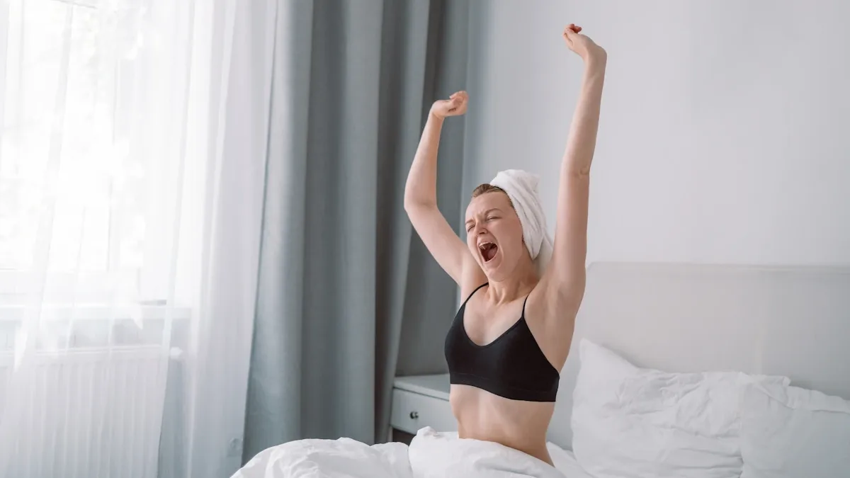 Une femme s&rsquo;étire dans son lit le matin