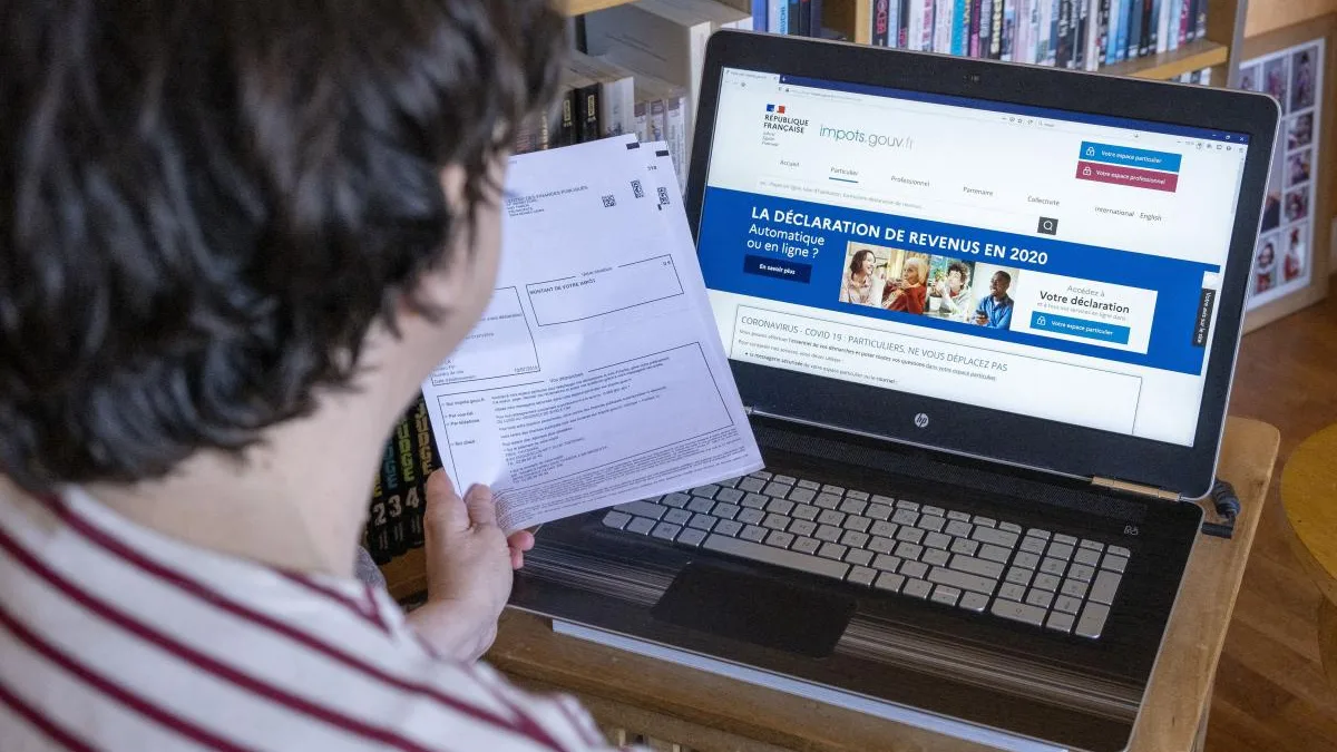 Une personne devant son écran d&rsquo;ordinateur, en train de remplir sa déclaration de revenus sur impots.gouv.fr