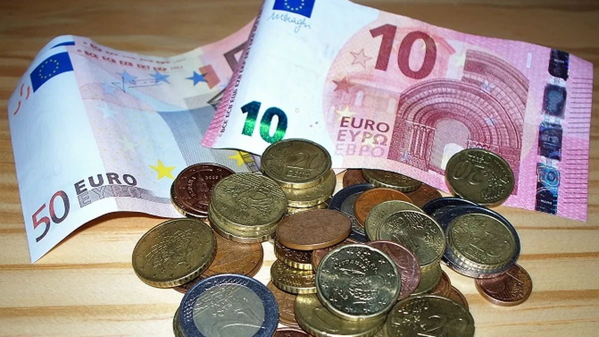 Des billets et des pièces en euros éparpillés sur une table, pour illustrer le pouvoir d&rsquo;achat