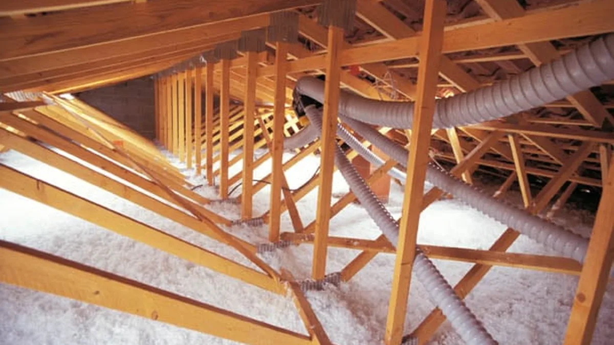 Des combles isolés par soufflage, la laine de verre recouvrant le plancher