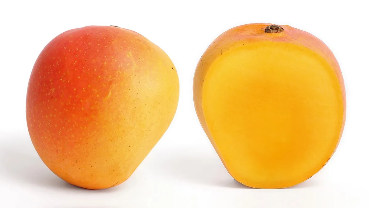 Une mangue coupée en deux, la chair orange et juteuse