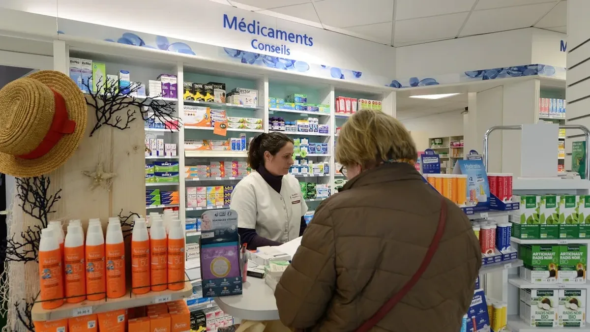Une pharmacienne conseille une cliente au comptoir d&rsquo;une pharmacie française