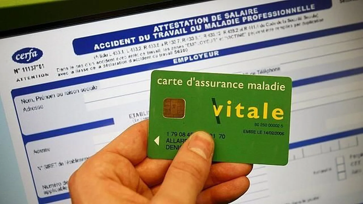 Une main tient une carte Vitale devant un formulaire administratif de santé