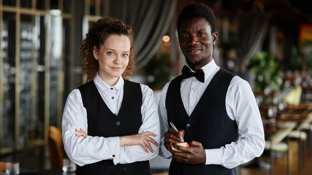 Deux serveurs dans un restaurant, secteur où les demandes d&rsquo;acomptes sont les plus fréquentes