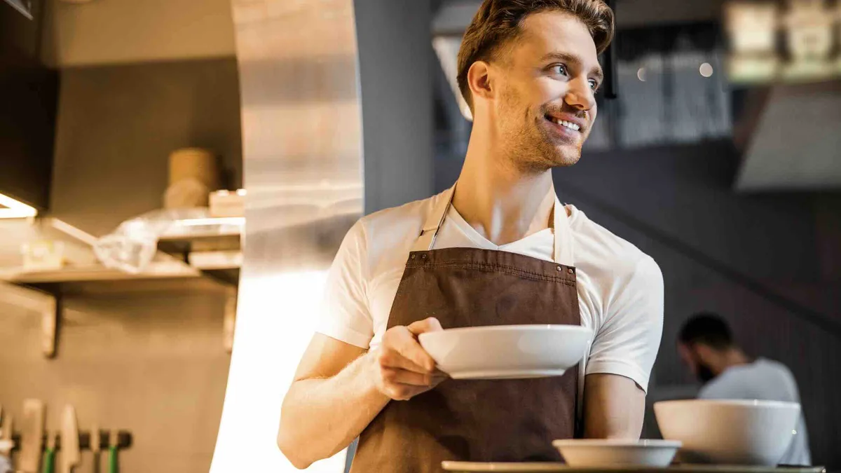 Un employé de cuisine en tablier : la restauration, le commerce et la construction concentrent les demandes