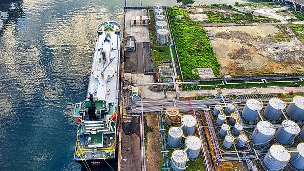 Un pétrolier accosté à un terminal avec des cuves de stockage de carburant