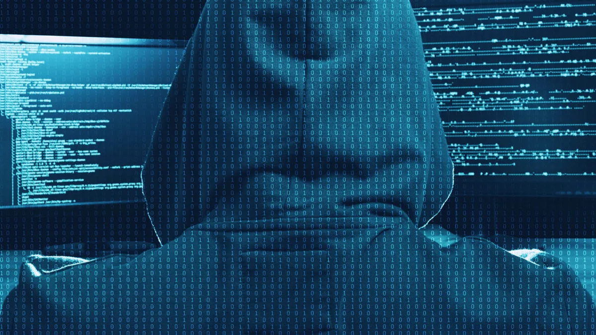 Un pirate informatique devant des écrans de code