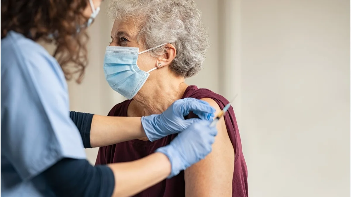 Une femme âgée reçoit son vaccin contre la grippe dans le bras
