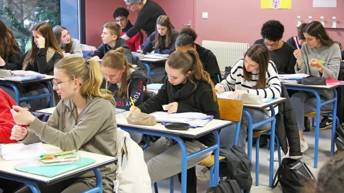 Des enseignants échangent avec leurs élèves dans une salle de classe de lycée
