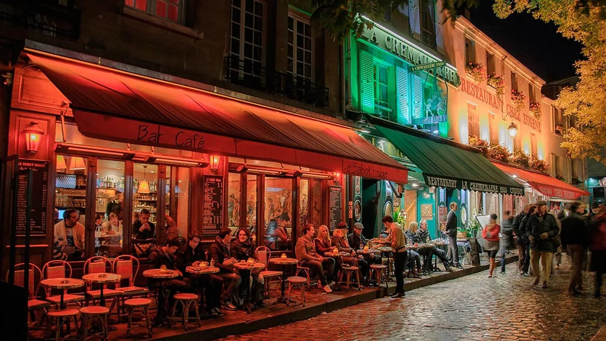 Paris la nuit, avec des passants dans une rue
