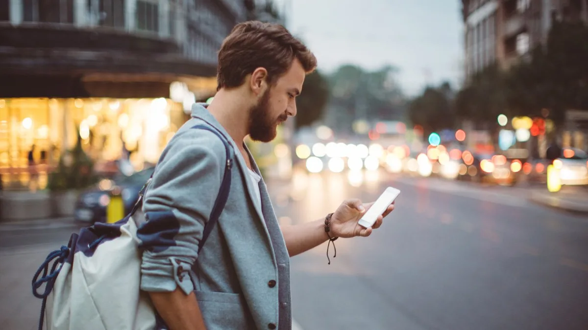 Un abonné consulte son smartphone dans la rue