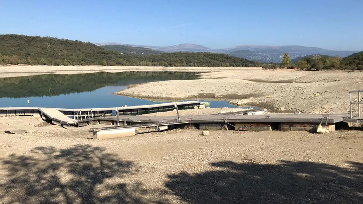 Vue aérienne d&rsquo;une rivière française en juillet 2026, réduite à un filet d&rsquo;eau entre de vastes bancs de sable