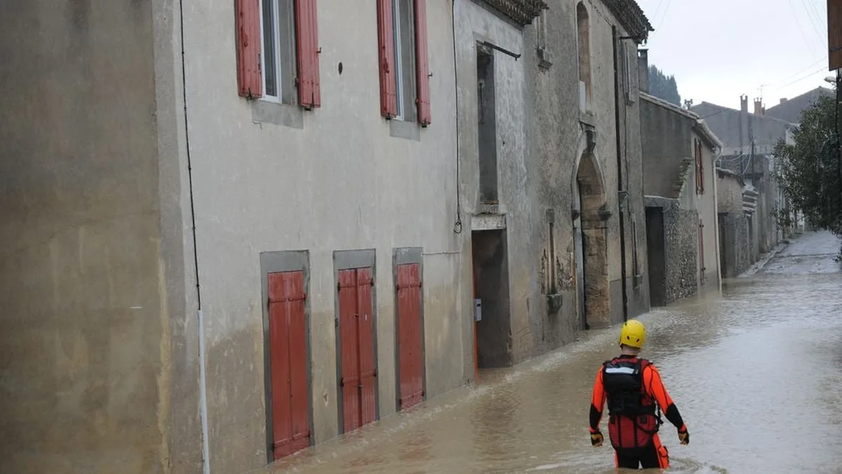 Une rue inondée sous un orage méditerranéen, avec des voitures et des débris emportés par l&rsquo;eau