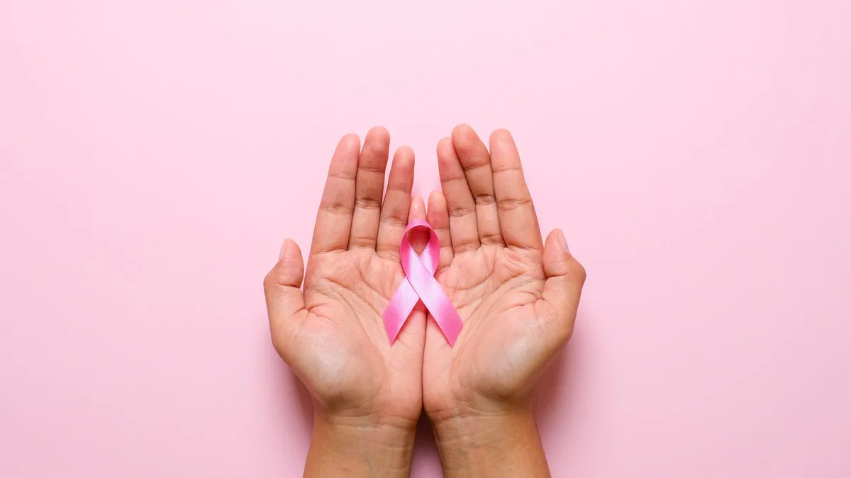 Des mains tiennent le ruban rose, symbole d&rsquo;Octobre rose