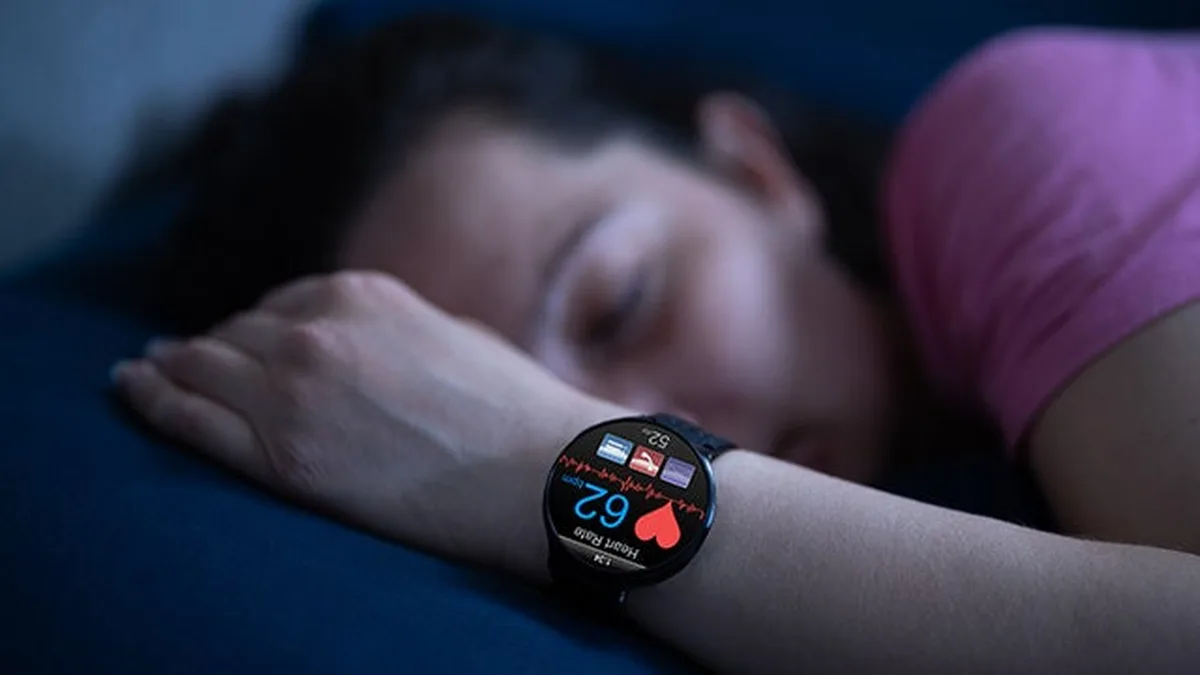 Une femme dort avec une montre connectée au poignet