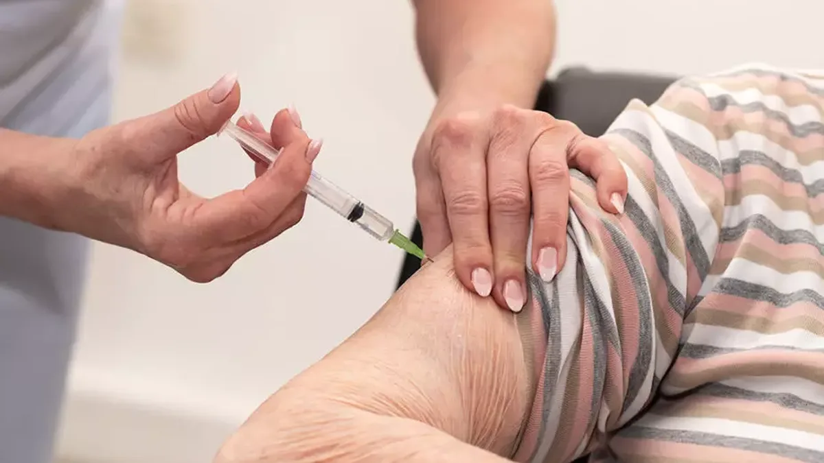 Une personne âgée reçoit une injection dans le bras lors d&rsquo;une séance de vaccination