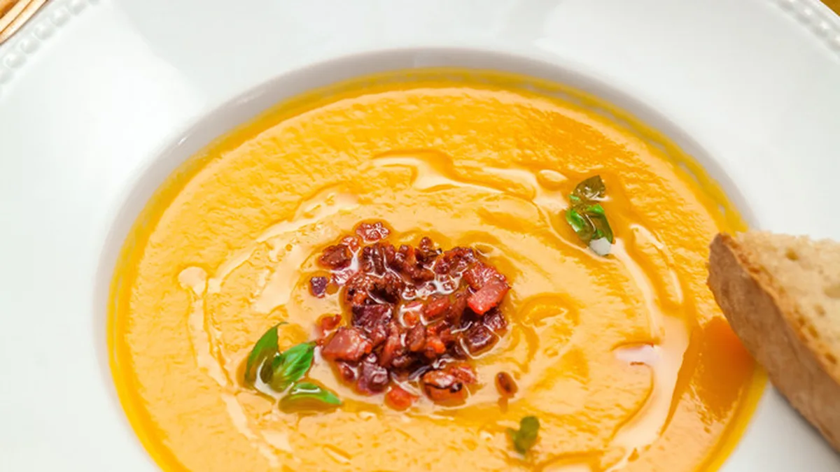 Velouté de potimarron onctueux servi dans une assiette creuse