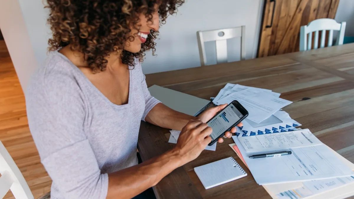 Une salariée consulte ses comptes sur son téléphone, un geste devenu courant pour vérifier ses droits