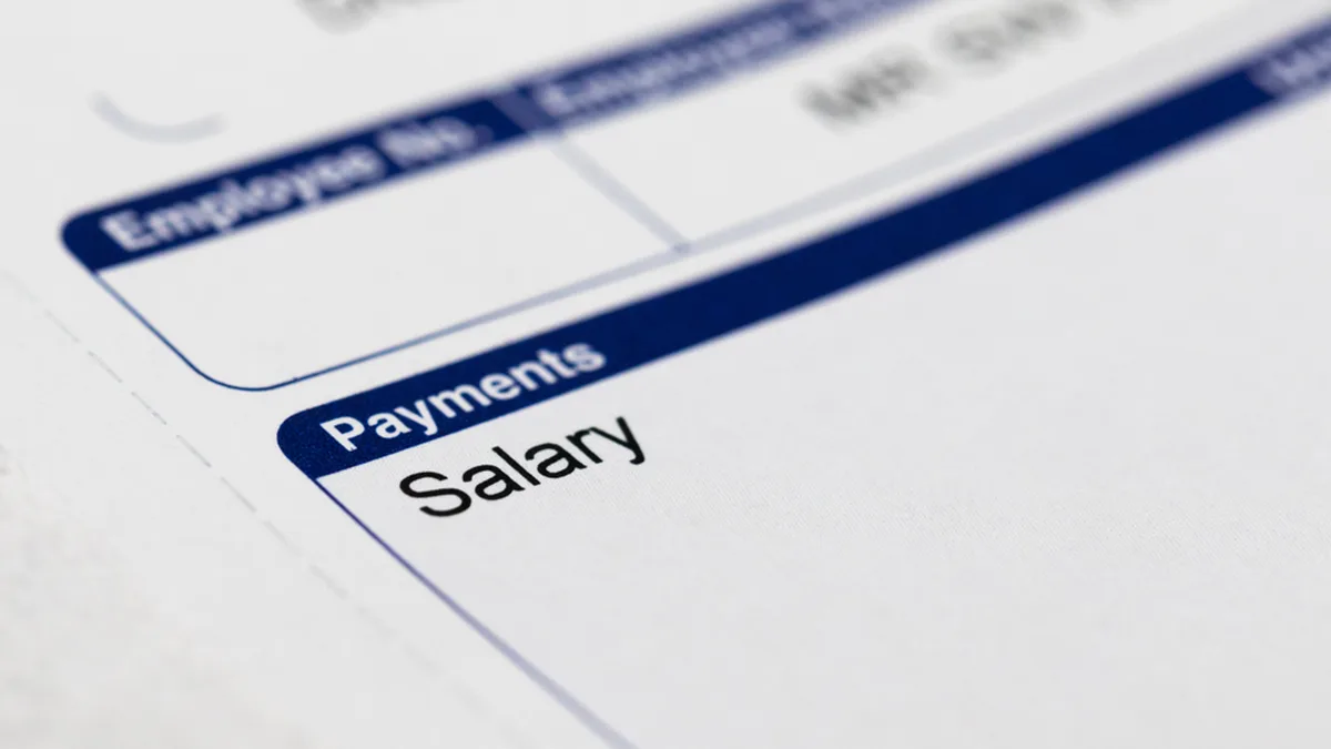 Un salarié relit sa fiche de paie : le montant net social y figure et sert de base au calcul de la prime