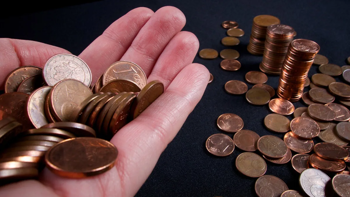 Une main tenant des pièces en euros, symbole du pouvoir d&rsquo;achat des ménages