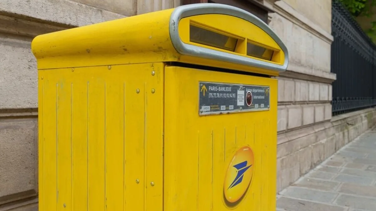 Une boîte aux lettres jaune de La Poste dans une rue de Paris