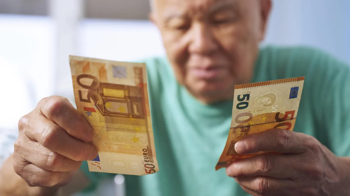 Un retraité tient des billets de 50 euros