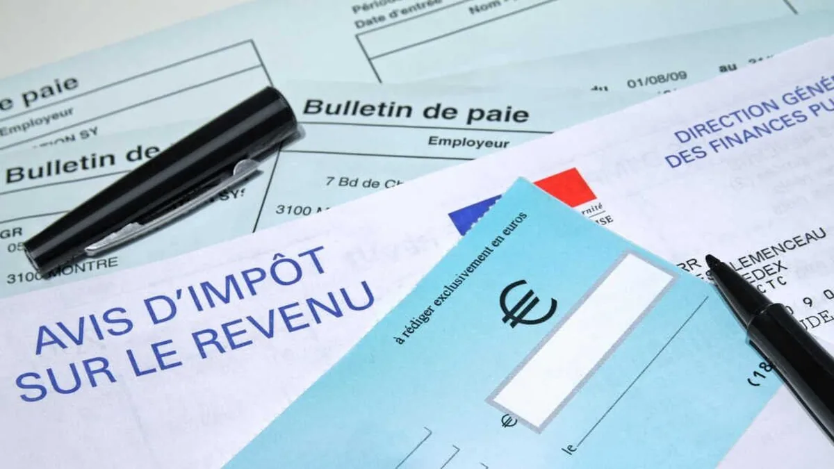 Avis d&rsquo;impôt, bulletin de paie et chéquier sur un bureau