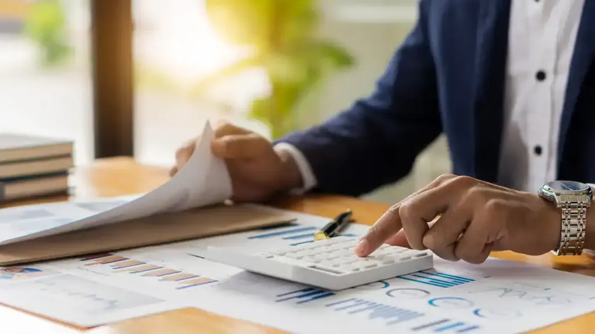 Une calculatrice et des documents fiscaux sur un bureau