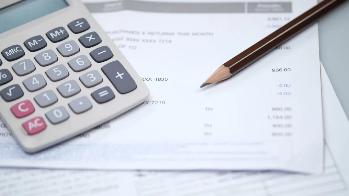 Calculatrice et factures sur une table, budget d&rsquo;un foyer