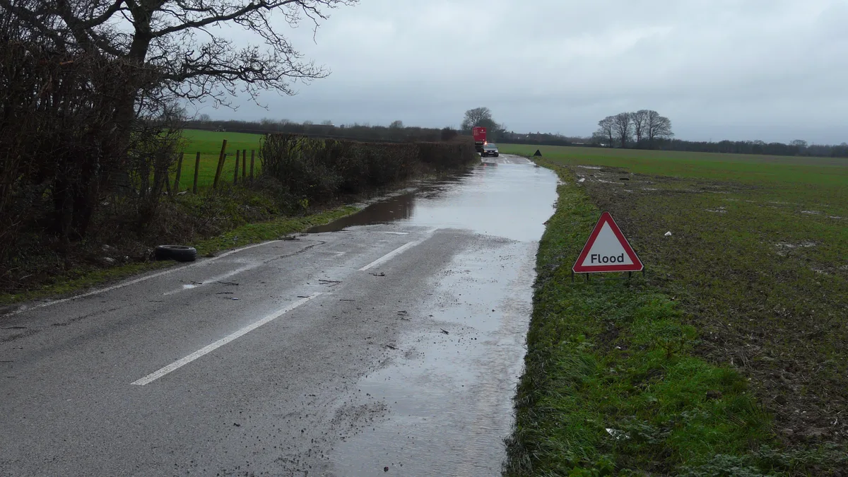 Route inondée après de fortes pluies, un risque accru avec des sols déjà saturés