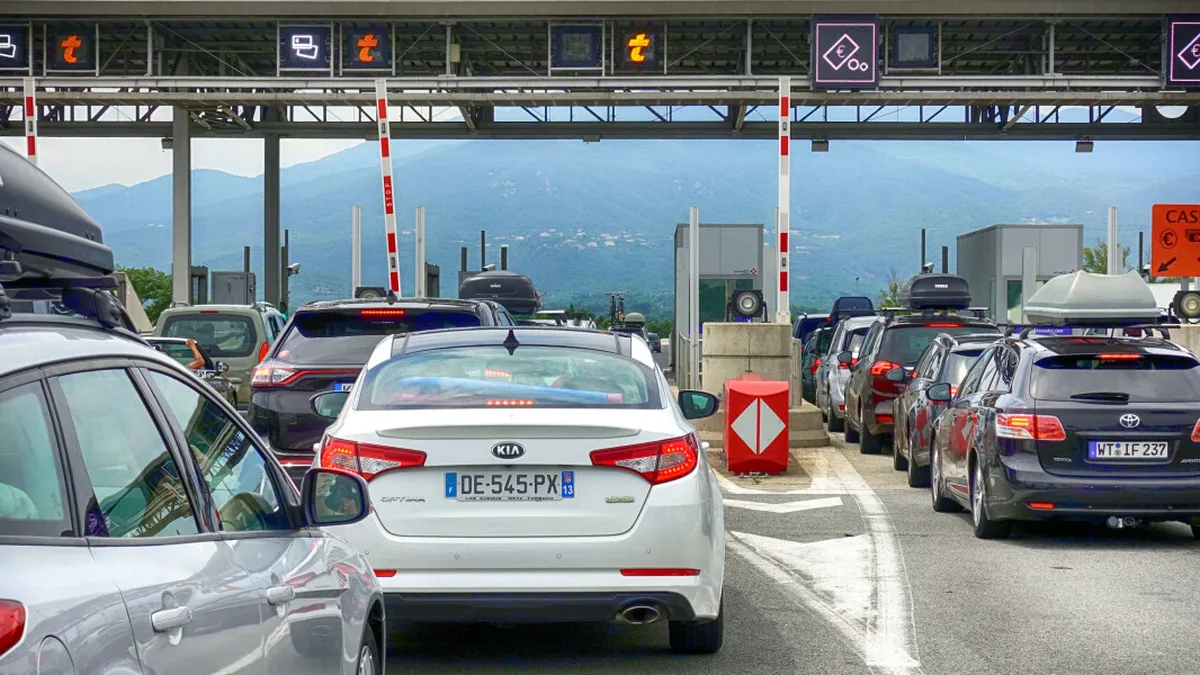 Des voitures sur une autoroute française à l&rsquo;approche d&rsquo;un péage : la fiscalité routière pourrait basculer de la pompe vers une redevance annuelle
